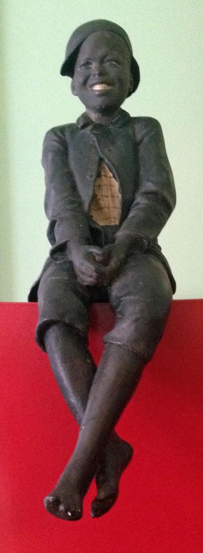 FIGURE OF A SEATED BLACK BOY