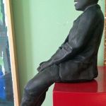 FIGURE OF A SEATED BLACK BOY