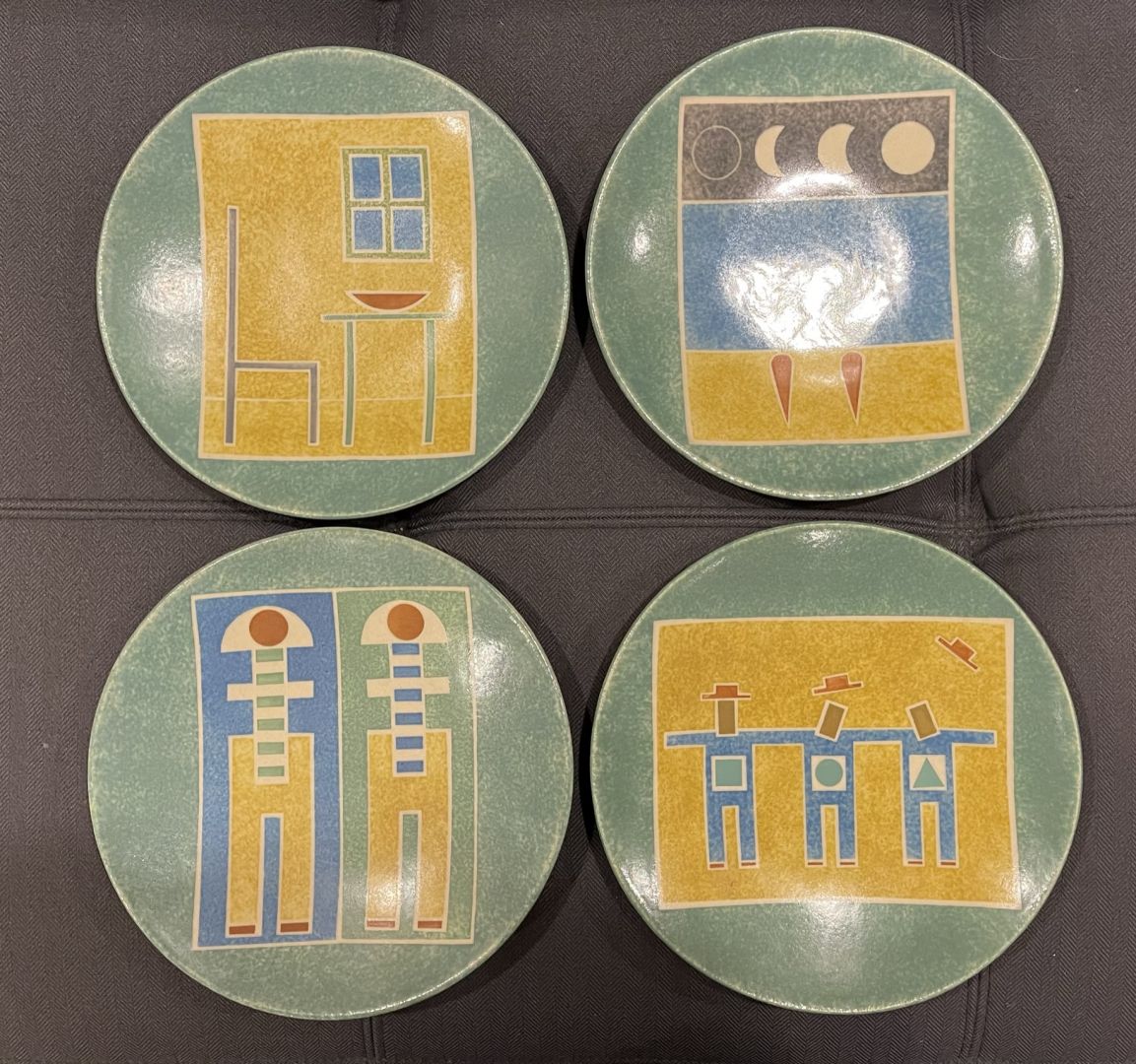 SET OF FOUR GREEN PLATES WITH FIGURATIVE DESIGNS IN COLORS